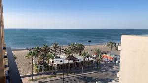 a view of a beach and the ocean from a building at PERLA DEL SOL in Torremolinos