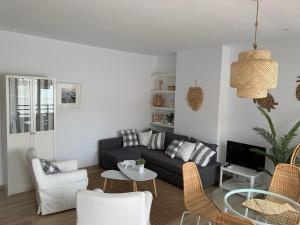 uma sala de estar com um sofá, uma mesa e cadeiras em PERLA DEL SOL em Torremolinos