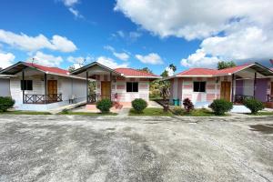 a row of houses with red roofs at OYO 90284 Kampung Stay Kilimu in Ranau