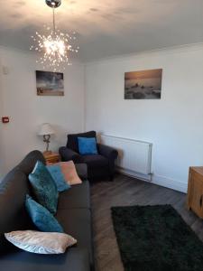 ein Wohnzimmer mit einer Couch und einem Sessel in der Unterkunft Beachmount Holiday Apartments in Colwyn Bay + 57 Fotos
