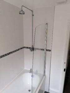 a white bathroom with a shower and a tub at No 1 Church Street in Whitchurch