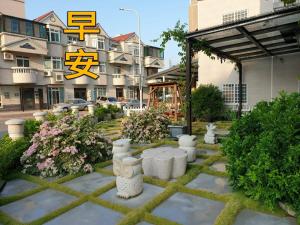 a garden with white vases in front of a building at Loving kinmen Homestay in Jincheng
