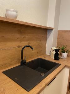 a kitchen sink with a black counter top at Hotel Italia in Görlitz +24 photos