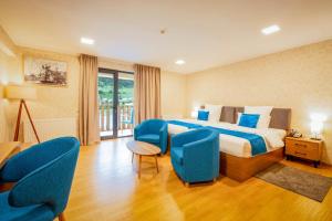 a hotel room with a bed and blue chairs at Gistola Hotel Mestia in Mestia +37 photos