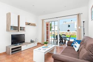 a living room with a couch and a tv at Villa Menorca BAY 4 by Mauter Villas in Sa Caleta