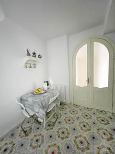 a white room with a table and a door at Casa Di Nicola in Cetara