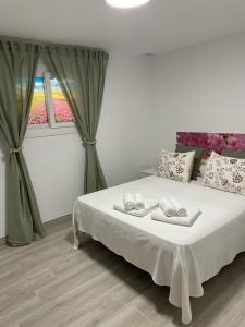 a bedroom with a bed with two towels on it at casa espiga in Benalmádena