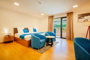 梅斯蒂亚Gistola Hotel Mestia的酒店客房,配有床和蓝色椅子