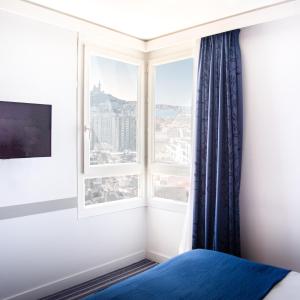 a bedroom with a window with a view of the city at Holiday Inn Express Marseille Saint Charles, an IHG Hotel in Marseille