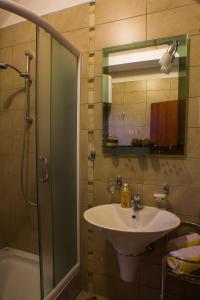 bagno con lavandino e doccia con specchio di DMM Apartments a Tivat