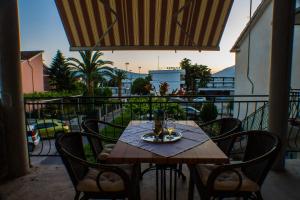 a wooden table and chairs on a balcony at DMM Apartments in Tivat
