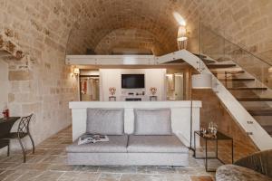 
a living room filled with furniture and a staircase at Cenobio Hotel in Matera
