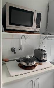 a microwave sitting on top of a kitchen counter at Ascot Comfort in Perth +16 photos