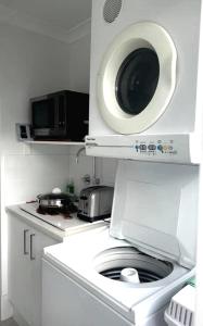 a kitchen with a washing machine and a microwave at Ascot Comfort in Perth