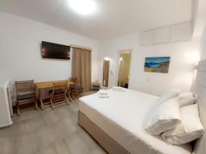 a bedroom with a bed and a table and chairs at AGNADEMA Luxury Residences in Schinoussa