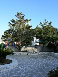 eine Terrasse mit Flaggen und Bäumen vor einem Gebäude in der Unterkunft AGNADEMA Luxury Residences in Schinoussa