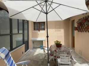 a table with a white umbrella on a patio at Corte Navari - GuestHouse Fred in Pietrasanta +10 photos