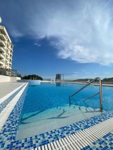 a swimming pool with blue tiles on the side of a building at Comfort studio with sea view and swimming pool in Becici