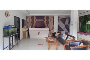 a living room with a couch and a table at Hotel Sri Indrawati Puncak Mitra RedDoorz in Bogor
