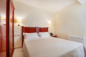 Postel nebo postele na pokoji v ubytování Hotel Regina Elena