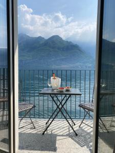 una mesa en un balcón con vistas al agua en Al Molo 5 - Lake Front en Oliveto Lario