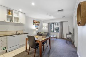 cocina y sala de estar con mesa y sillas en Auckland Apartment City Centre en Auckland