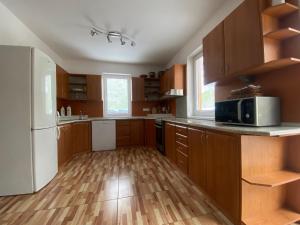 a kitchen with wooden cabinets and a white refrigerator at Chata Slanica in Námestovo