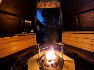 - un barbecue en plein air avec une cheminée dans une cabine dans l'établissement Villa Lumi 10 henkilölle, Himos Länsihuippu, à Jämsä