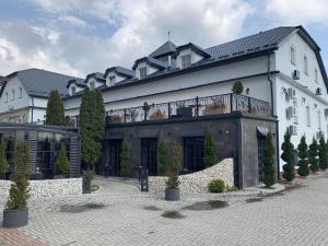 ein großes weißes Gebäude mit Balkon darüber in der Unterkunft Hotel Kameleon in Tarnobrzeg