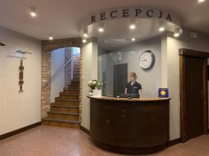 une femme debout à la réception dans un bâtiment dans l'établissement Hotel Kameleon, à Tarnobrzeg