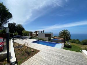 a house with a swimming pool and a wooden deck at Boutique Ocean Terrace Luxury - SSHOUSING in San Sebastián
