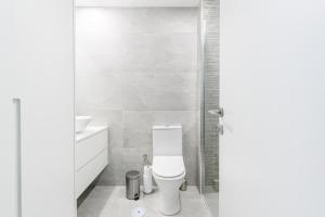 a white bathroom with a toilet and a sink at Estúdio R&M - Gerês in Geres