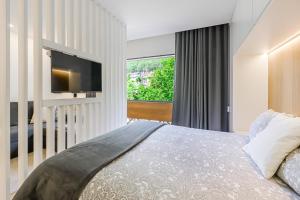 a bedroom with a bed and a tv on a wall at Estúdio R&M - Gerês in Geres