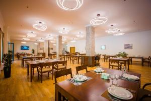 梅斯蒂亚Gistola Hotel Mestia的配有木桌椅的餐厅