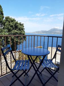 una mesa y sillas en un balcón con vistas al océano en Casa Santa en Calvi