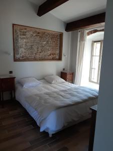 a bedroom with a bed and a painting on the wall at Casa Santa in Calvi