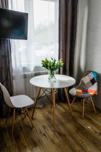 stół i krzesła z wazonem kwiatów w obiekcie Daszówka Bieszczady w mieście Ustrzyki Dolne