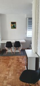 two chairs in a room with a desk and a table at APARTMENT 075 TUZLA in Tuzla