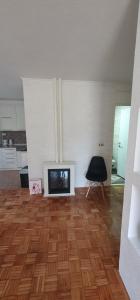 a living room with a television and a chair at APARTMENT 075 TUZLA in Tuzla