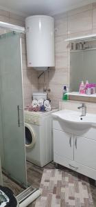 a bathroom with a sink and a washing machine at APARTMENT 075 TUZLA in Tuzla