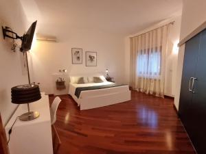 een slaapkamer met een bed en een houten vloer bij Villa Vittoria in Mesagne