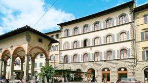 a large building with many windows on a street at Palazzo dei Ciompi Suites in Florence