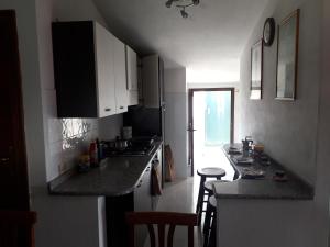 a kitchen with white cabinets and a counter top at Spacious attic apartment in Olmedo +13 photos