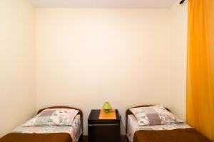 a bedroom with two beds and a table with a lamp at Guest House Curic in Dubrovnik