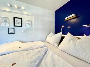 two beds in a bedroom with blue walls at Entzückende Garconniere im Herzen Spittals in Spittal an der Drau