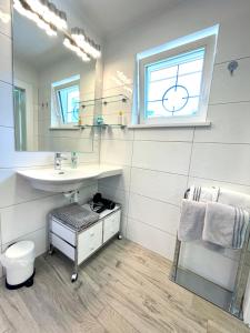 La salle de bains est pourvue d'un lavabo et d'un miroir. dans l'établissement Entzückende Garconniere im Herzen Spittals, à Spittal an der Drau