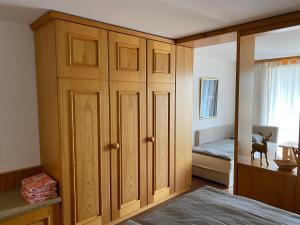 - une chambre avec une grande armoire en bois et un lit dans l'établissement Moderne Ferienwohnung in Laax - Modern apartment in Laax, à Laax