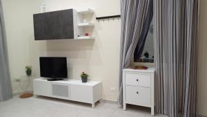 een woonkamer met een tv en een witte dressoir bij Casetta Delia in Palermo