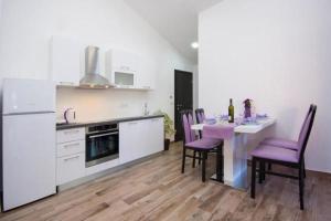 kuchnia ze stołem i fioletowymi krzesłami w obiekcie Apartment Perla w mieście Brodarica