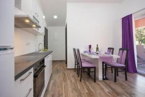 kuchnia ze stołem z fioletowymi krzesłami w obiekcie Apartment Perla w mieście Brodarica